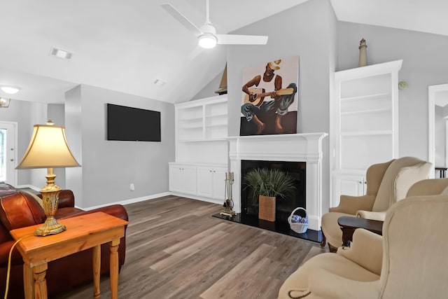 living room featuring visible vents, lofted ceiling, wood finished floors, baseboards, and a ceiling fan