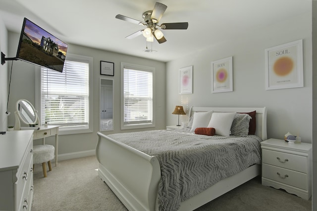 bedroom featuring multiple windows, ceiling fan, and light carpet