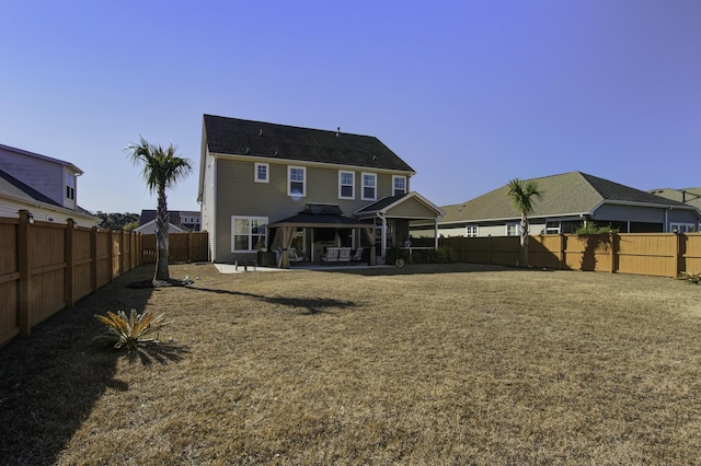 rear view of property with a yard and a patio