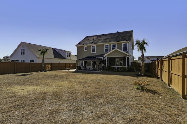 back of house with a yard and a patio