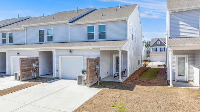 townhome / multi-family property with central AC unit and a garage