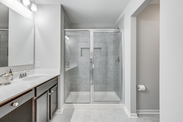 bathroom with tile patterned floors, vanity, and a shower with shower door