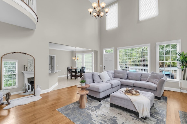 591 Two Mile Run, Johns Island, SC 29455 - living area featuring a chandelier, a towering ceiling, healthy amount of natural light, a fireplace, and light wood-style floors