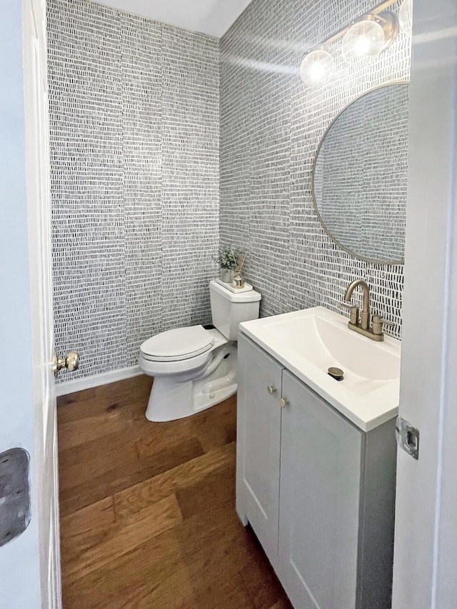 bathroom with vanity, toilet, tile walls, and wood finished floors