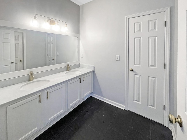 full bathroom with double vanity, tile patterned flooring, baseboards, and a sink