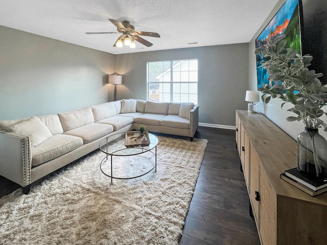 living room with baseboards, a textured ceiling, dark wood finished floors, visible vents, and a ceiling fan