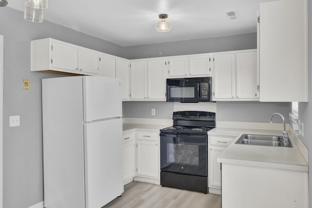 kitchen with black appliances, a sink, light countertops, and white cabinets