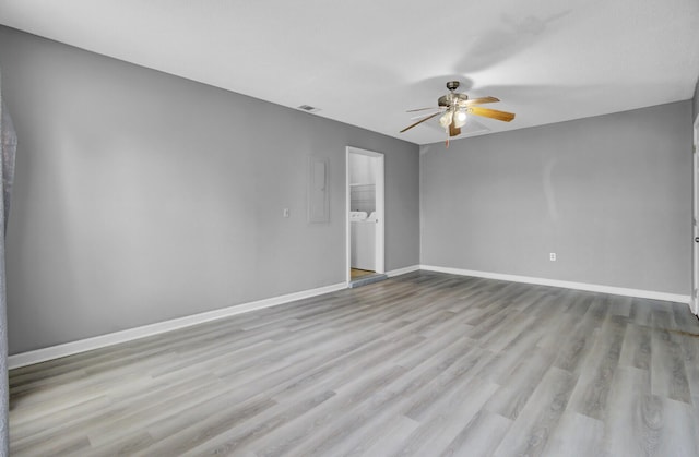 empty room featuring ceiling fan, wood finished floors, visible vents, and baseboards