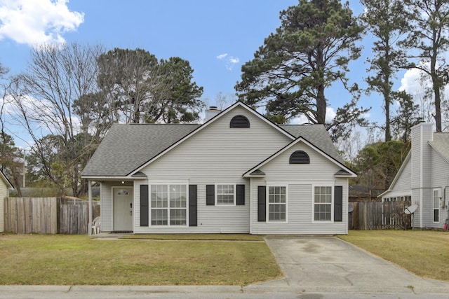 traditional home with a front lawn, a chimney, a shingled roof, and fence