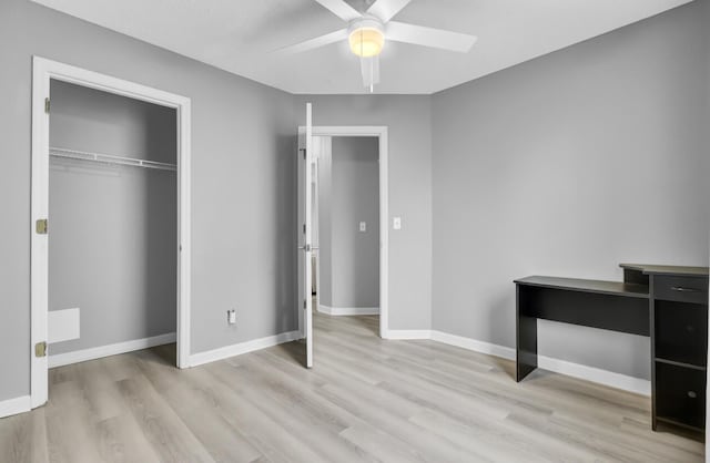 unfurnished bedroom featuring light wood-style floors, a closet, baseboards, and a ceiling fan