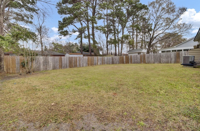 view of yard with a fenced backyard and central AC unit