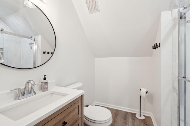 full bath with a marble finish shower, visible vents, toilet, wood finished floors, and vaulted ceiling