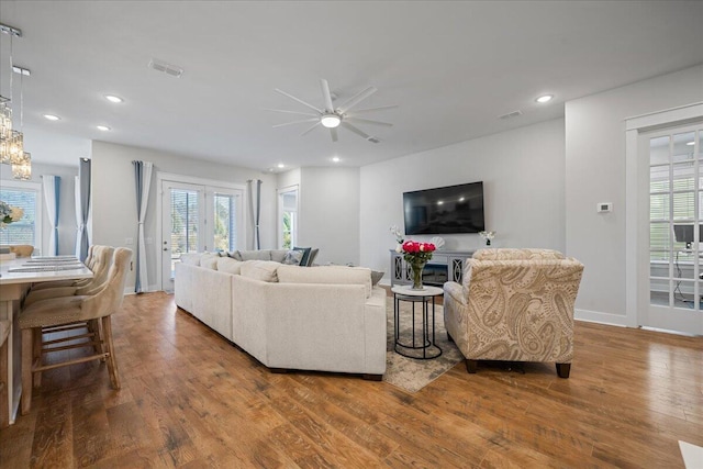 living room featuring ceiling fan, french doors, and wood-type flooring