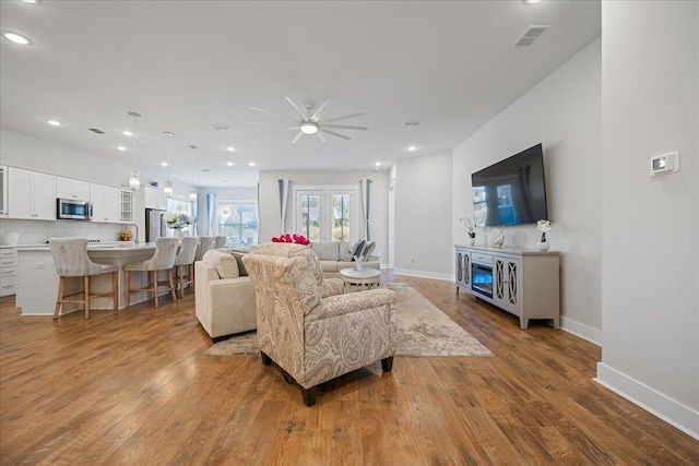 living room featuring ceiling fan and light wood-type flooring