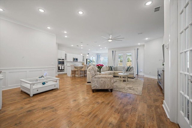 living room featuring ceiling fan, french doors, and hardwood / wood-style floors