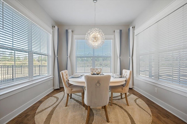 dining area with dark hardwood / wood-style flooring, a chandelier, and a wealth of natural light