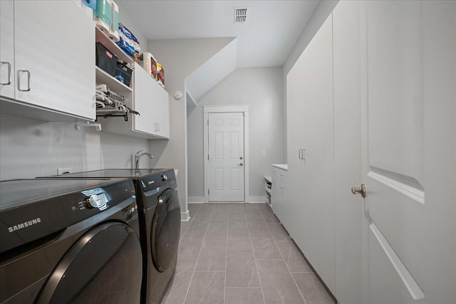 washroom with independent washer and dryer, cabinets, and light tile patterned floors