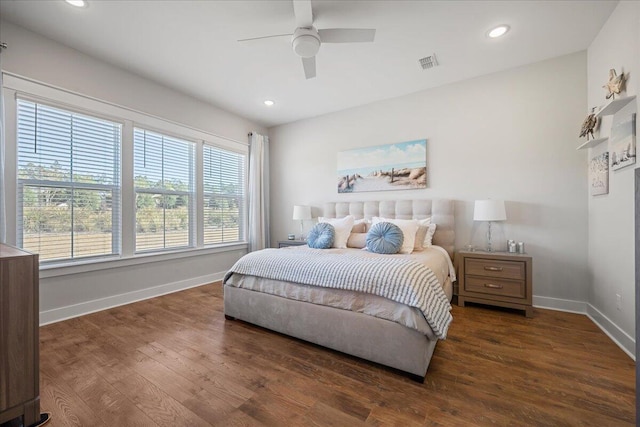 bedroom featuring ceiling fan, dark hardwood / wood-style floors, and multiple windows