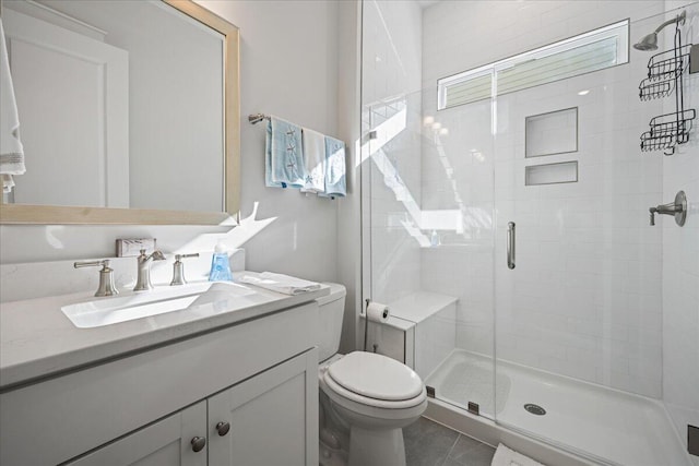 bathroom featuring toilet, an enclosed shower, vanity, and tile patterned floors