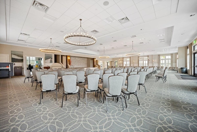 dining room with an inviting chandelier, a raised ceiling, and carpet