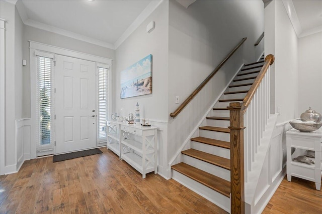 foyer entrance featuring hardwood / wood-style floors and crown molding