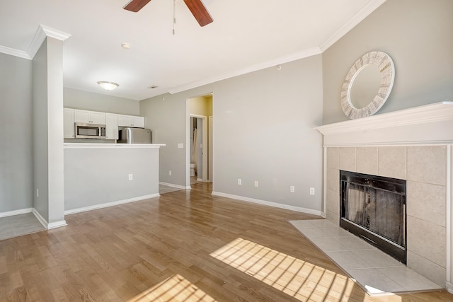 unfurnished living room featuring a fireplace, light hardwood / wood-style flooring, ceiling fan, and ornamental molding