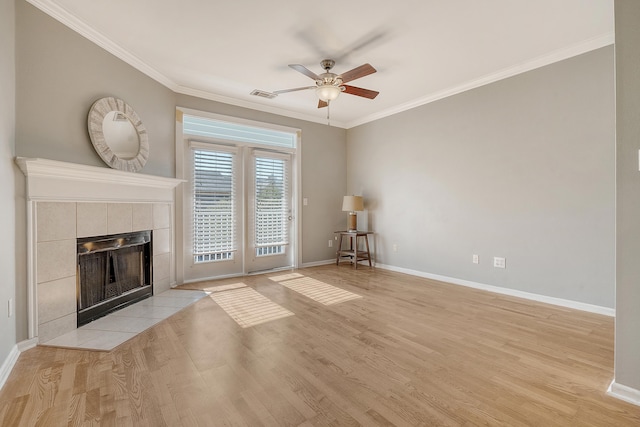 unfurnished living room with a tile fireplace, light wood-type flooring, ceiling fan, and crown molding