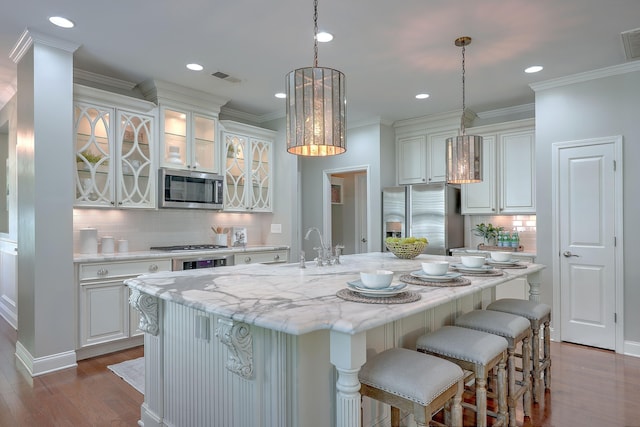 2036 Kings Gate Ln, Mount Pleasant, SC 29466 - kitchen with appliances with stainless steel finishes, a kitchen bar, wood finished floors, decorative backsplash, and white cabinets