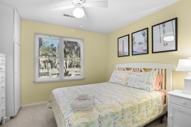 bedroom featuring light colored carpet, ceiling fan, and a closet