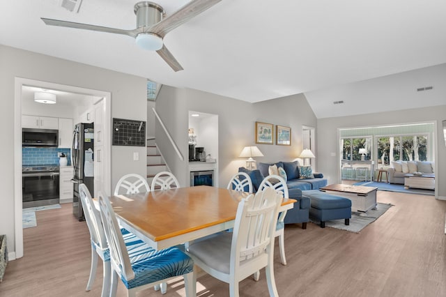 dining space with lofted ceiling, light hardwood / wood-style floors, and ceiling fan