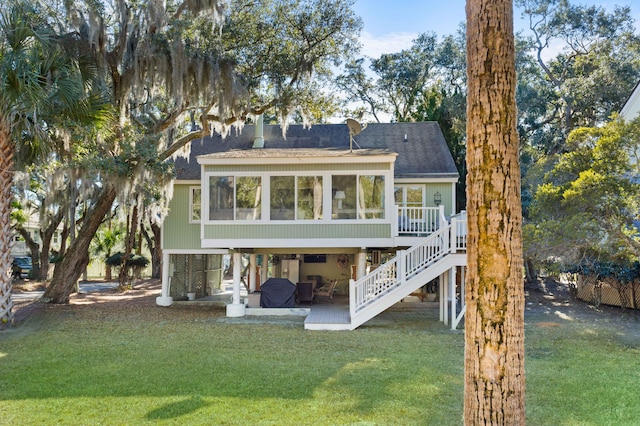 back of property with a patio, a sunroom, and a lawn