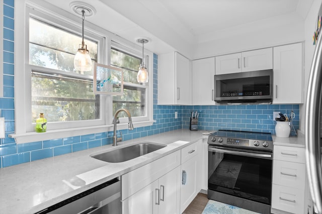 kitchen with white cabinetry, sink, light stone countertops, and appliances with stainless steel finishes