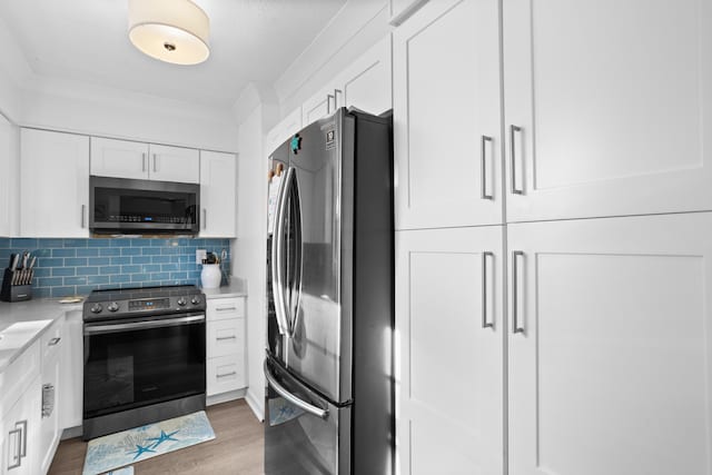 kitchen featuring tasteful backsplash, stainless steel appliances, dark wood-type flooring, and white cabinets