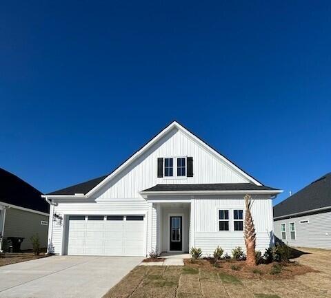 modern farmhouse with board and batten siding, concrete driveway, and an attached garage