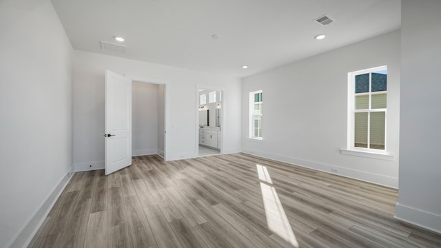 unfurnished bedroom featuring baseboards, visible vents, and wood finished floors