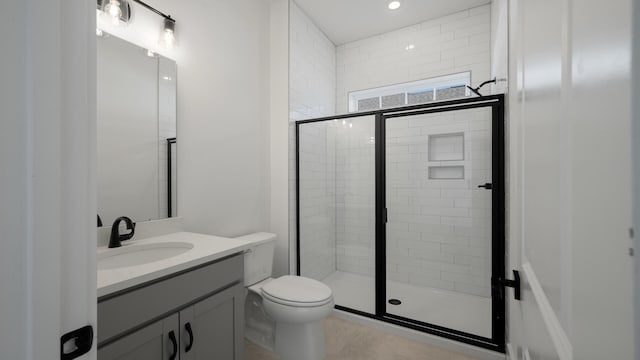 full bath with a stall shower, vanity, and toilet