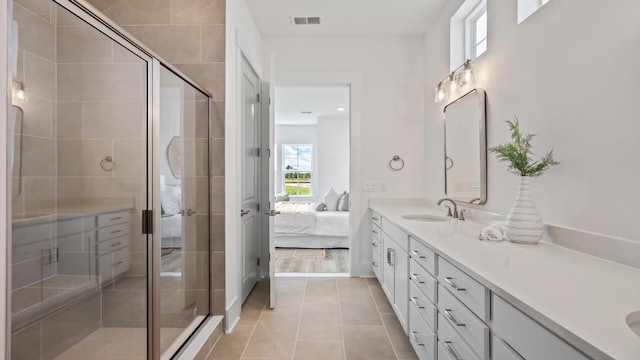 bathroom with an enclosed shower, vanity, and tile patterned flooring