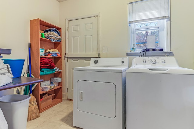 clothes washing area with washing machine and clothes dryer and light tile patterned floors