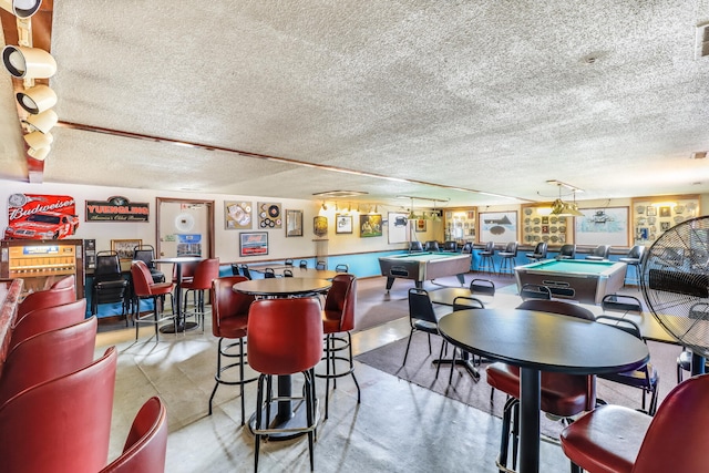 dining space featuring pool table, concrete floors, and a textured ceiling