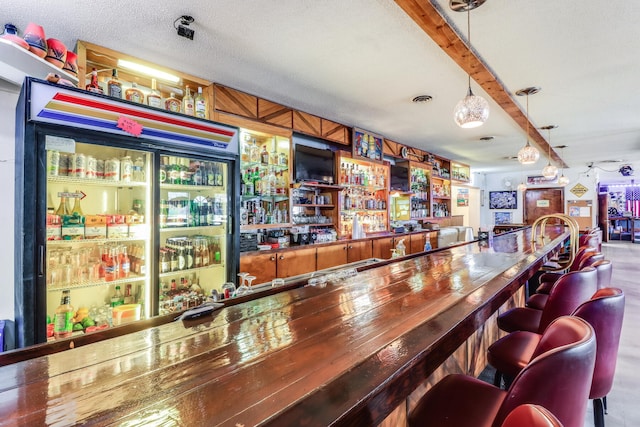 bar featuring hanging light fixtures and a textured ceiling