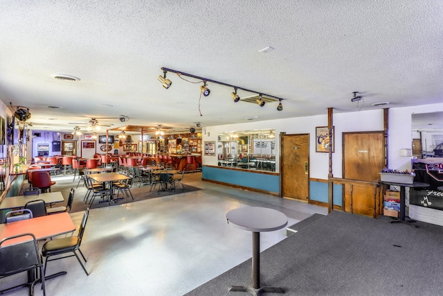 miscellaneous room featuring a textured ceiling and bar