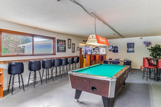 playroom with a textured ceiling, billiards, and bar