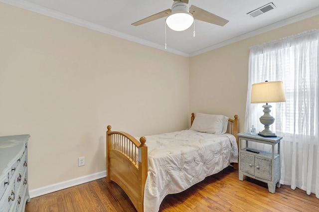 bedroom featuring hardwood / wood-style floors, ceiling fan, and ornamental molding