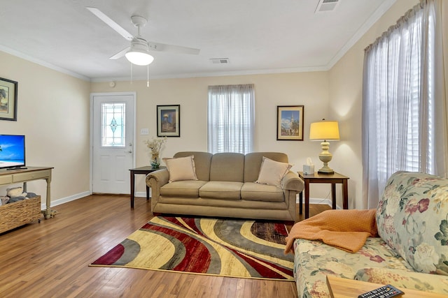 living room featuring hardwood / wood-style floors, ceiling fan, and ornamental molding