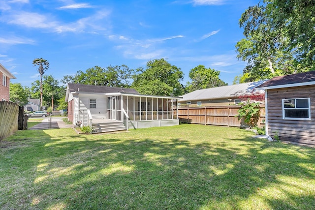 back of house featuring a yard and a sunroom