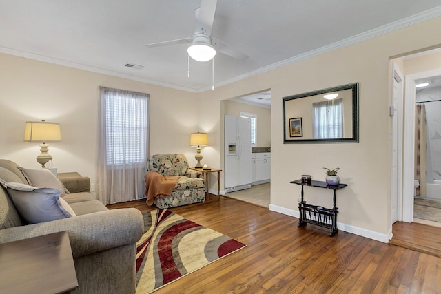 living room featuring hardwood / wood-style flooring, crown molding, and ceiling fan