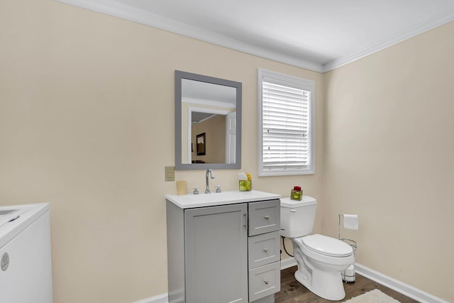 bathroom with toilet, wood-type flooring, vanity, washer / clothes dryer, and ornamental molding