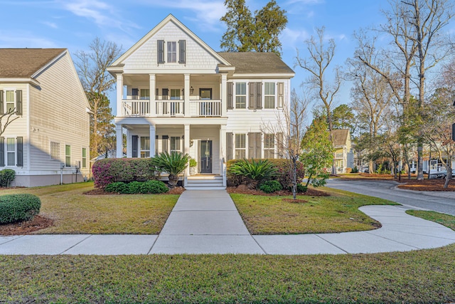 greek revival inspired property featuring a front yard, a balcony, and a porch