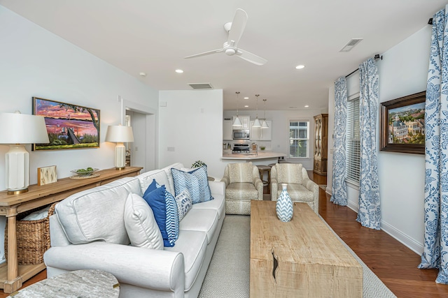 living area with visible vents, dark wood-type flooring, baseboards, recessed lighting, and a ceiling fan