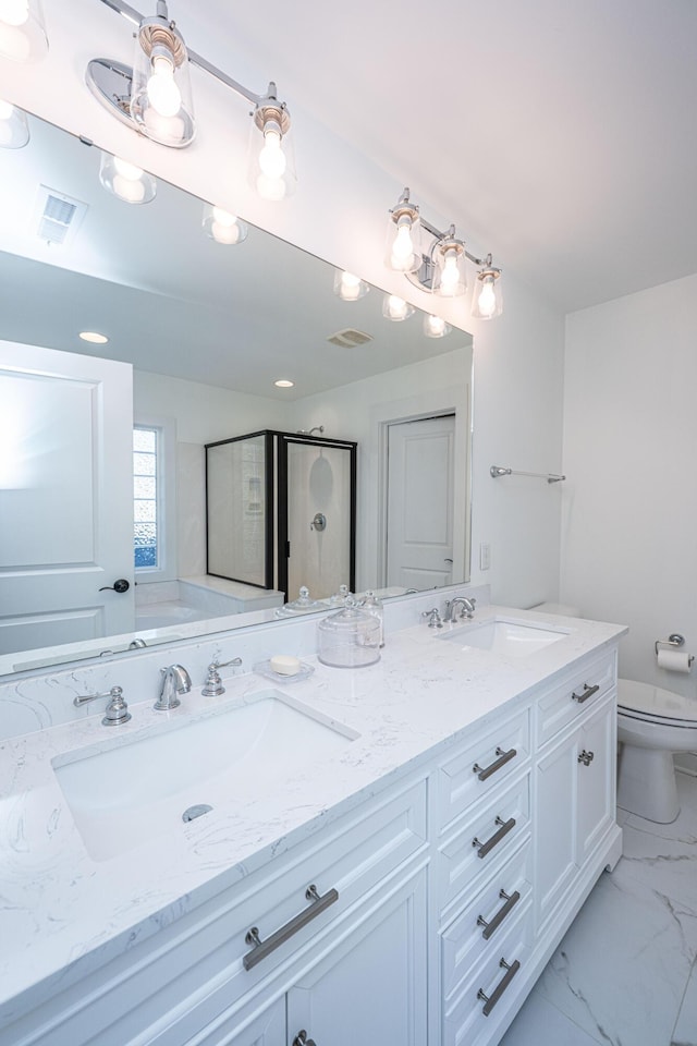 bathroom featuring double vanity, marble finish floor, toilet, and a sink